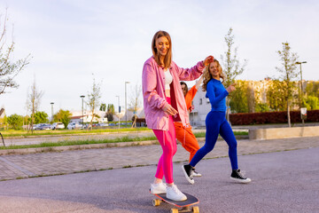 Ragazze in città che si divertono correndo sullo skateboard.