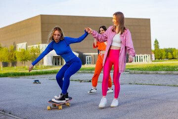 Ragazze in città che si divertono correndo sullo skateboard.