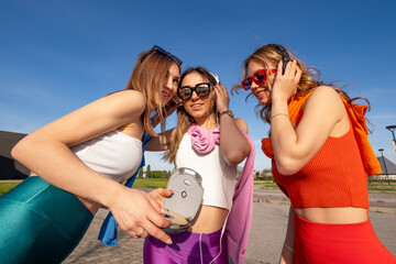 tre ragazze felici che ascoltano musica in esterna