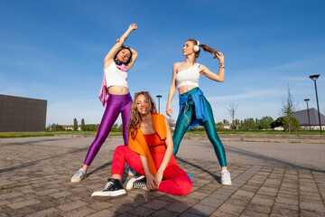 Ragazze che ballano e provano una coreografia all'aperto.