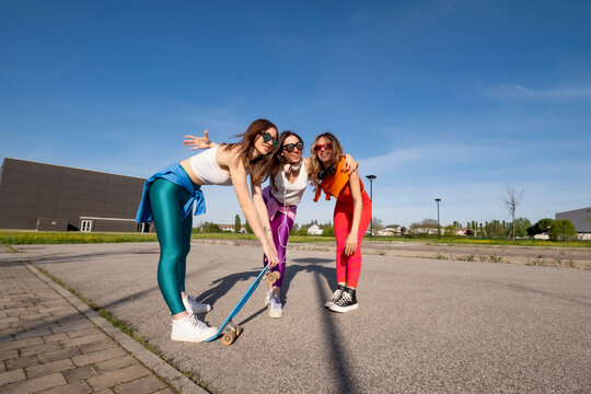 Ragazze in citt&agrave; che si divertono correndo sullo skateboard.