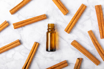 Cinnamon aromatic essential oil and cinnamon sticks on a wooden background. Aromatherapy. Organic cosmetic oil. Spa concept. Place for text. Copy space.