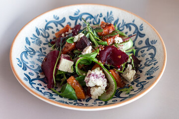 Sumptuous beetroot salad, tangy feta, quinoa sprinkle, in a handcrafted blue-patterned bowl....
