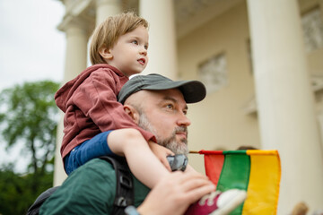 Cute little boy and his father holding tricolor Lithuanian flag celebrating Lithuanian Statehood Day in Vilnius - 793869905