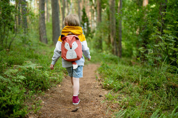 Cute little boy with a backpack having fun outdoors on sunny summer day. Child exploring nature. Kid going on a trip. - 793870531