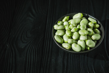 fresh greens broad beans fava on a dark background