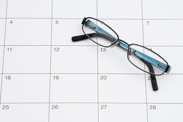 Eye exam doctor appointment with glasses and sticky note on a calendar