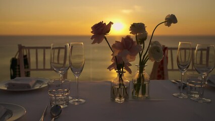 Dinner setting at sunset. Decoration flowers candles romantic wedding reception party outdoor.