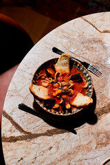 Rich, hearty seafood stew served with toasted bread. A luscious meal that encapsulates coastal flavors and culinary craftsmanship.