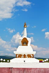 Close-up view of Buddhist Stupa of Enlightenment against backdrop of blue sky with clouds on foothill valley on Tunkinskiy Natural Park on sunny summer day. Siberia. Baikal region. Buryatia. Arshan