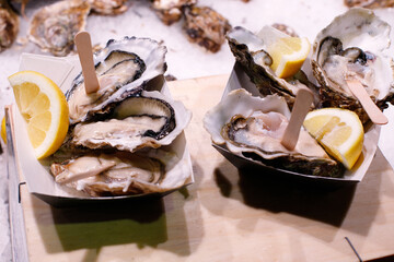 fresh oysters ready to eat with lemon slices at the market