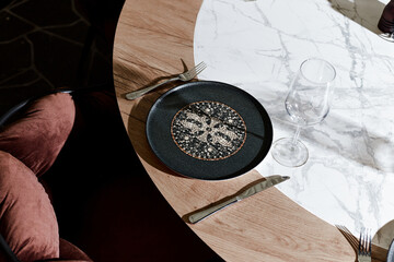 Chic dining setup featuring an intricate eastern plate on a marble table, poised for a luxury meal...