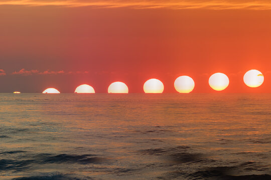 Sequential sunrise progression photos above the sea horizon