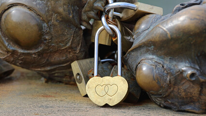 Brass Padlock With Two Hearts Locked at Bridge Fence Symbol of Love