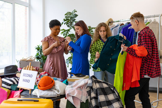 second-hand store, saving money and family budget, young people students at swap party try on clothes, bags, shoes and accessories, change clothes with each other, second hand for things, zero waste