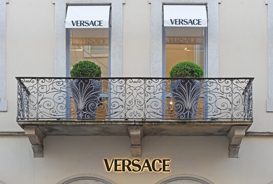 MILAN, ITALY &ndash; APRIL 11, 2024: Facade with white marquises, wrought iron balcon, buxus and black illuminated logo in Via Monte Napoleone. Versace is an Italian luxury fashion brand based in Milan
