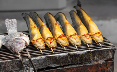Catfish is grilled on skewers over coals
