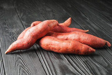 fresh sweet potatoes on a dark rustic background