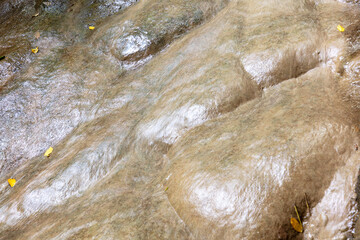Water flows down a stone wall in nature