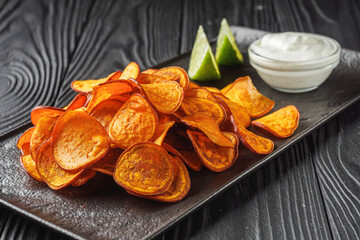 sweet potato chips on a dark wooden rustic background