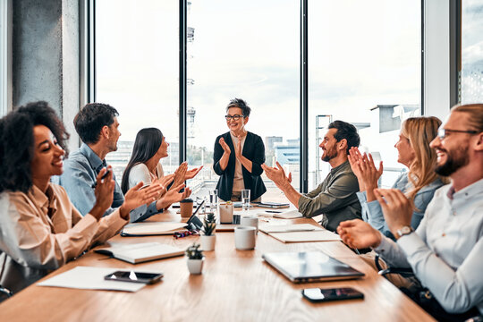 Successful team. Cheerful group of multinational colleagues celebrating gaining achievement with applause during meeting. Proud coworkers clapping hands while feeling motivation and powerfulness.