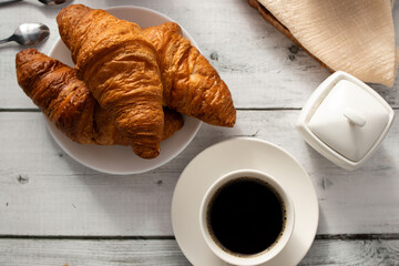 Cup of coffee and croissants and berries. on white wooden. breakfast. Morning.