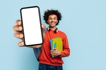 Happy man presenting smartphone blank screen on blue background