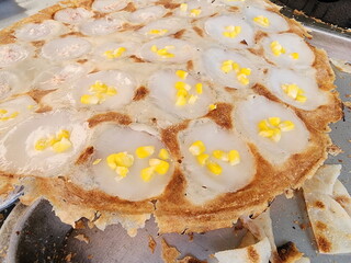 Thai Coconut Pudding Pan or Khanom Krok Pan is Traditional Thai desserts.  Baker sprinkling chopped sweetcorn and taro into the uncooked dough. Traditional Thai dessert made from flour, sugar, coconut