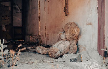 bear children's soft toy near the wall of a destroyed house in Ukraine