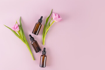 Three dark glass bottles with a dropper with a cosmetic product for daily self-care. Natural cosmetics. Top view. Flat lay. A copy space.