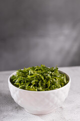 Plate with chopped kale leaves. Green cabbage leaves.