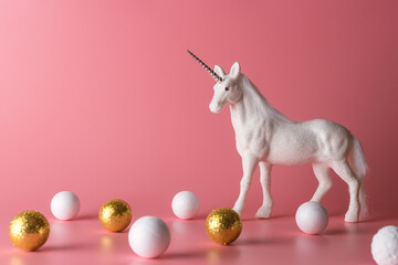 Minimal composition with glitter unicorn and white and gold decoration. Magical surreal background.