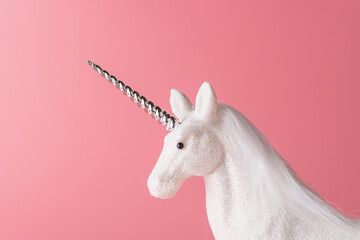 Creative composition with glitter unicorn on pink background. Minimal holiday concept.
