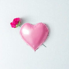 Pink heart balloon with flower on white background. Creative minimal love concept. Flat lay.