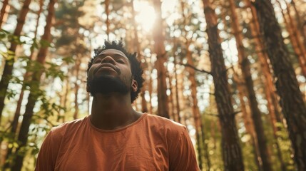 Naklejka premium african american man breathing fresh air in the forest nature connection and wellness concept