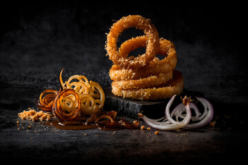 Fried onion rings on a black background. Generative AI,