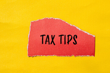 Tax tips words written on ripped red paper piece with yellow background. Conceptual tax tips...