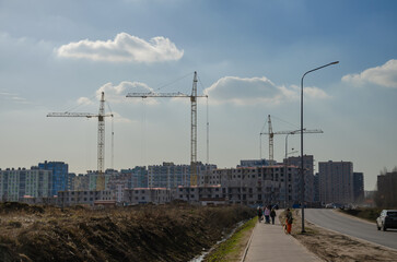 Urban construction of buildings, cranes on the background of the sky