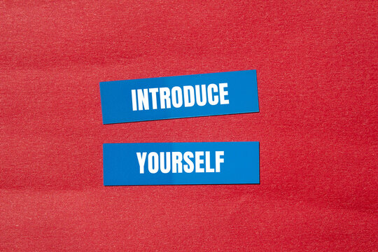 Introduce yourself words written on blue paper stickers with red background. Conceptual introduce yourself symbol. Copy space.