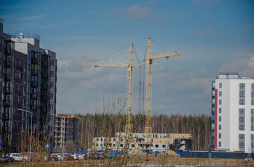 Fototapeta na wymiar Urban construction of buildings, cranes on the background of the sky