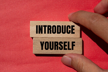 Introduce yourself words written on wooden blocks with red background. Conceptual introduce yourself symbol. Copy space.