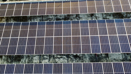 Aerial view of solar panels on the roof of a building. Top view of three rows of solar panels on...