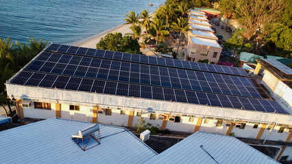 Solar panels on the roof of a building. Three rows of solar panels on the roof of a building by the...