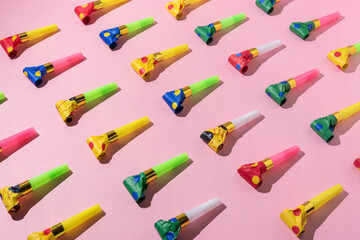 Colorful celebration pattern with party blower horns. Minimal party concept. Flat lay. - obrazy, fototapety, plakaty