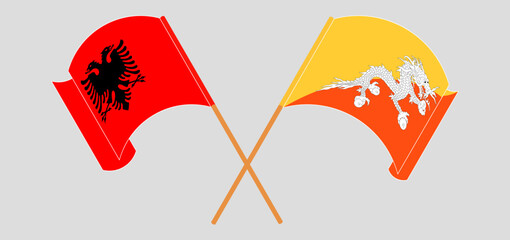 Crossed and waving flags of Albania and Bhutan