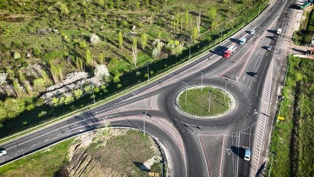 Vehicles on a roundabout junction. Roundabout with barriers and driver crosses road marking strips in roundabout. Roundabout traffic of cars on the circle ring road. Wrong lane, unsafe maneuvers.   
