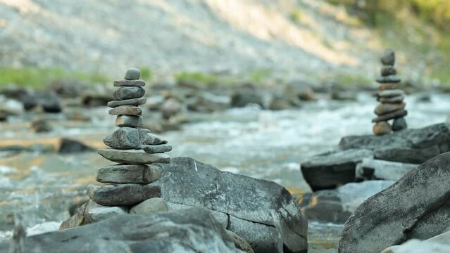 Video of small balanced stone towers on mountain river. Symbol of balance, meticulous work of balancing stones one on another