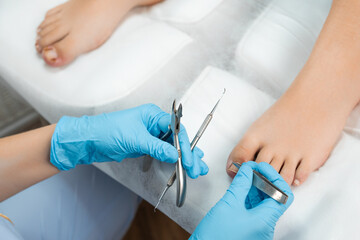 Professional medical pedicure using special nail instruments in the clinic