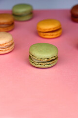 Colorful macarons on pink background. Selective focus.