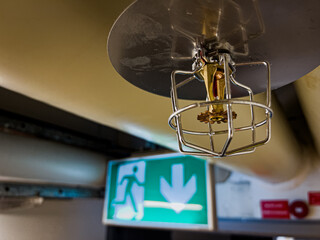 a close up shot of a fire security sprinkler head covered with a safety basket and water spill...